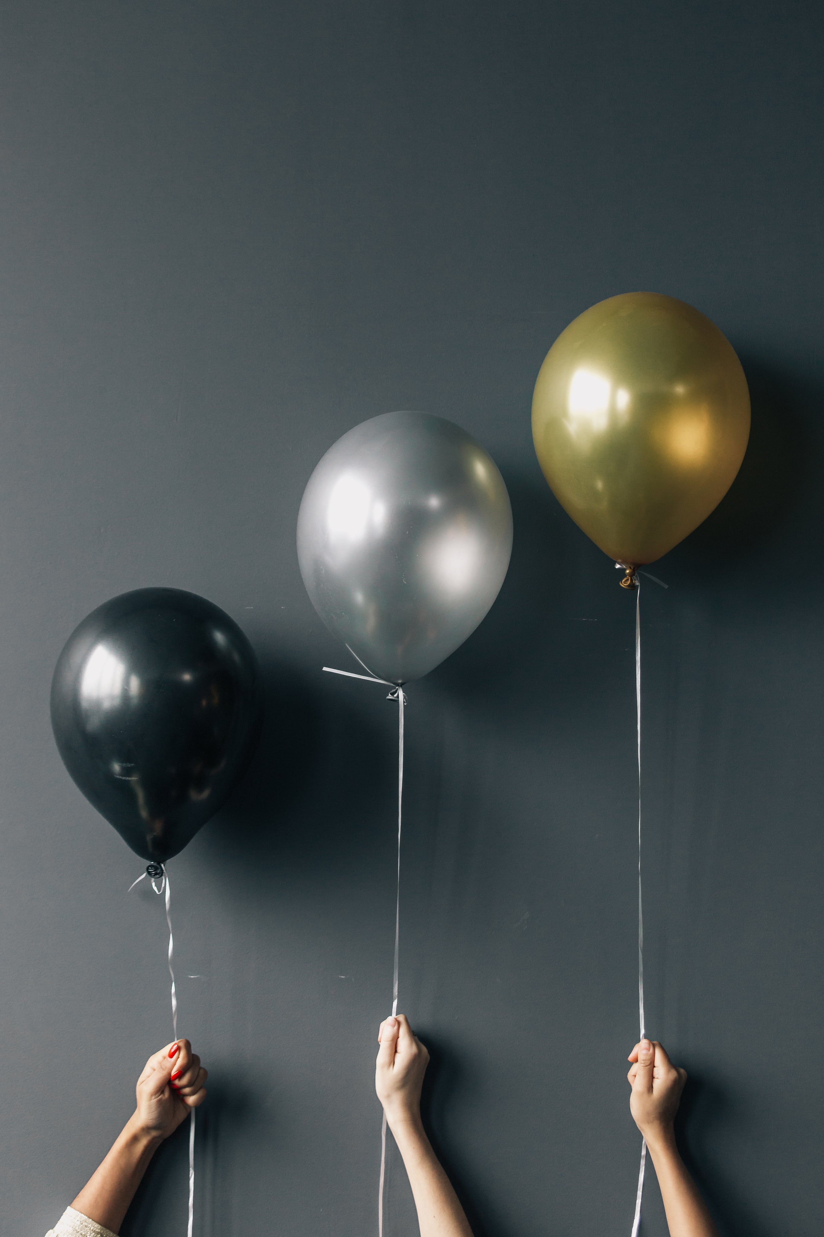 three-balloons-held-against-wall.jpg